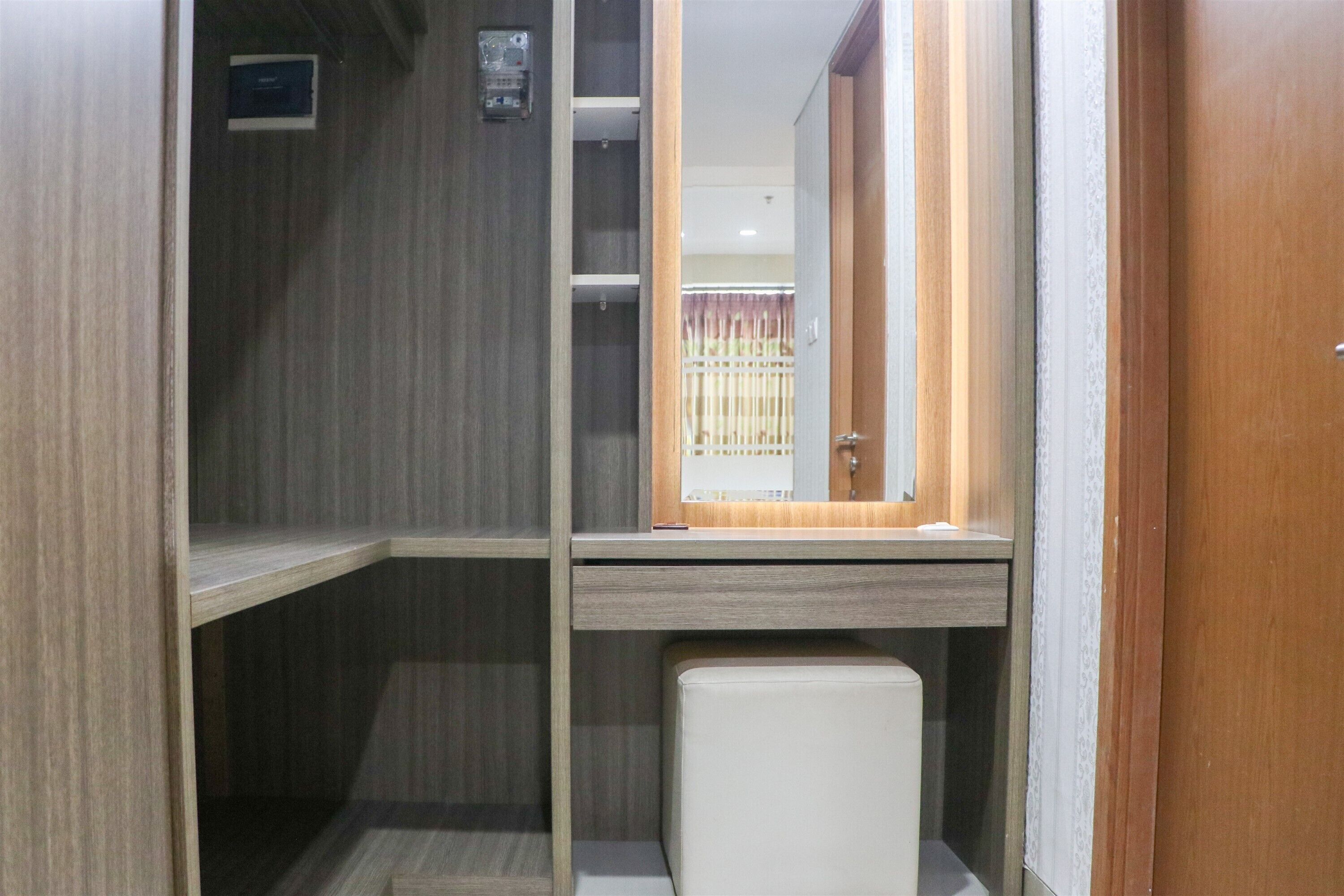 A compact bathroom with a wooden vanity, a mirror, and a toilet.