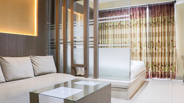 Une chambre moderne avec une cloison en verre, un canapé, un lit et une table basse en verre.