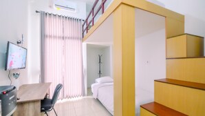 A room with a desk, chair, bed, and a staircase. - Enjoy Living And Homey Studio Dave Apartment (Depok)