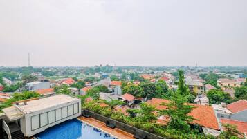 A rooftop pool with a view of a residential area.
