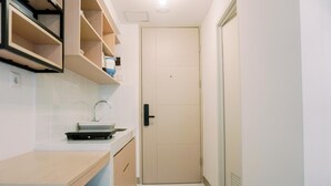 A compact kitchen with a countertop, sink, and storage cabinets. - Relax And Comfy Studio At Tokyo Riverside Pik 2 Apartment (Teluknaga)