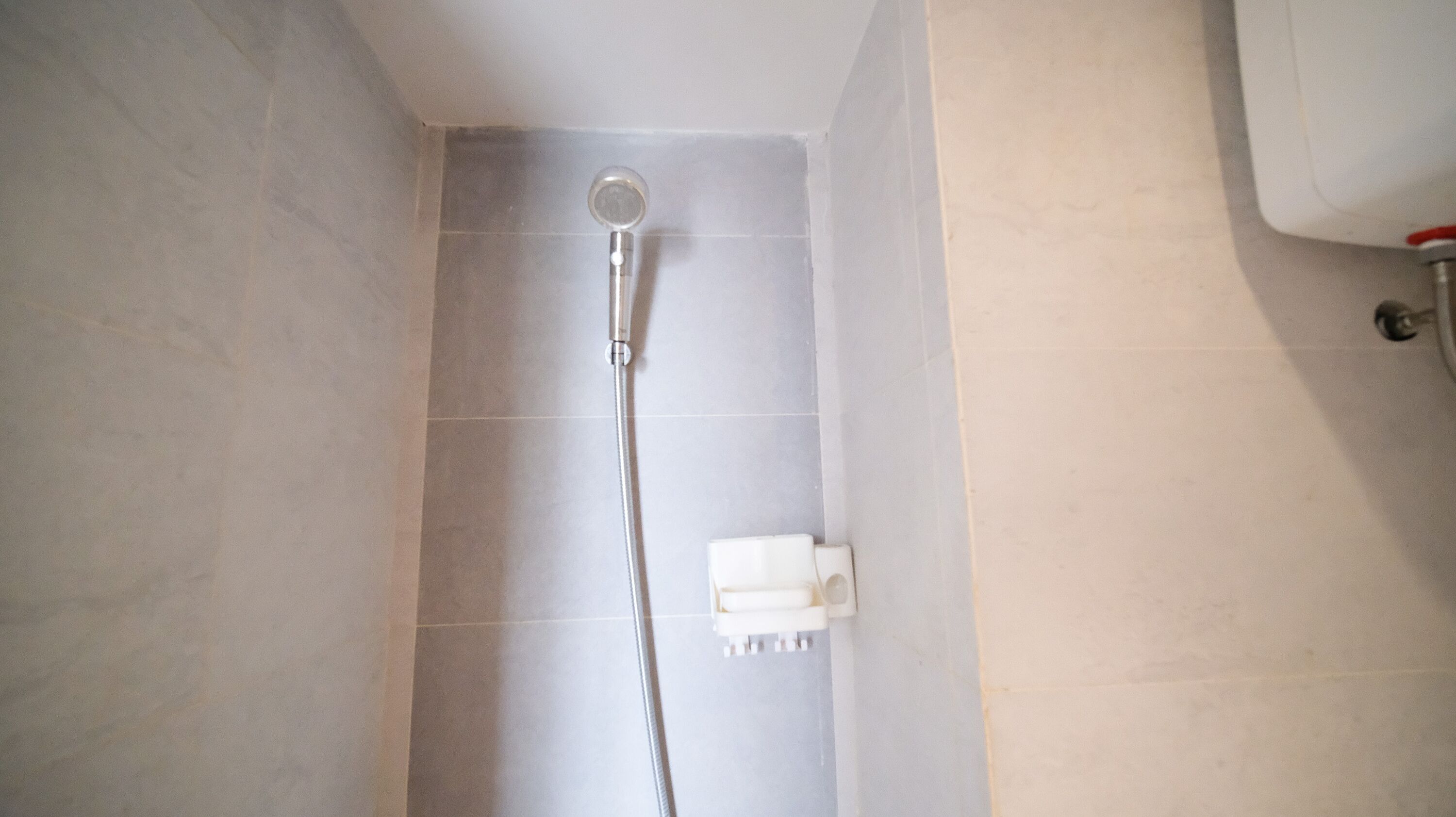 Una ducha con cabezal de ducha de mano y grifo empotrado.
