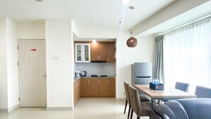 Eine moderne Küche mit Holzausstattung, einem Esstisch mit Stühlen und einem Kühlschrank.
