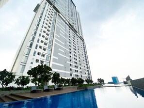 Un edificio alto con una piscina al frente.