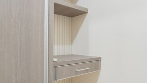 Un coin de pièce avec un meuble en bois, une petite étagère et un tiroir.