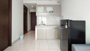 A modern kitchen with a built-in oven, a refrigerator, and a sink. - Cozy 2Br Apartment Mekarwangi Square Cibaduyut (Bandung)