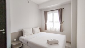 A hotel room with a single bed, a small bedside table, a window with curtains, and a door. - Cozy 2Br Apartment Mekarwangi Square Cibaduyut (Bandung)
