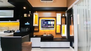 A modern kitchen with a built-in TV, a microwave, and a coffee machine. - Brand New And Good Simply 1Br At Uttara The Icon Apartment (Depok)