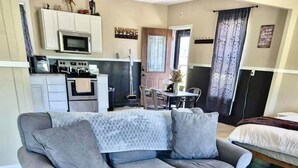 A living room with a grey sofa, a wooden coffee table, and a patterned rug.