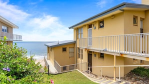 A two-story building with balconies, a staircase, and a view of the sea. - Golden-Sands- 3-66-Ocean-Pde (The Entrance)