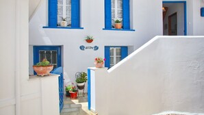 A white building with blue shutters and a 'Welcome' sign.