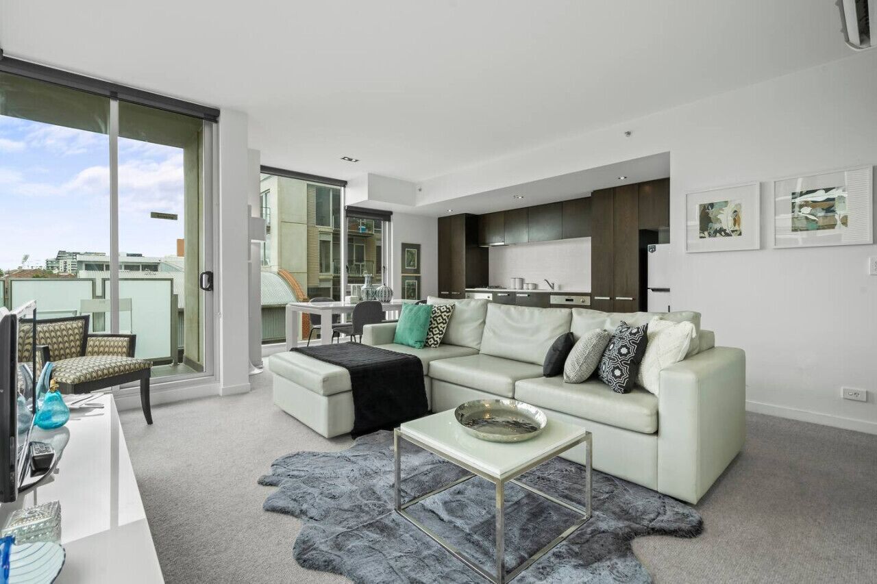 A modern living room with a sofa, coffee table, and a large window.