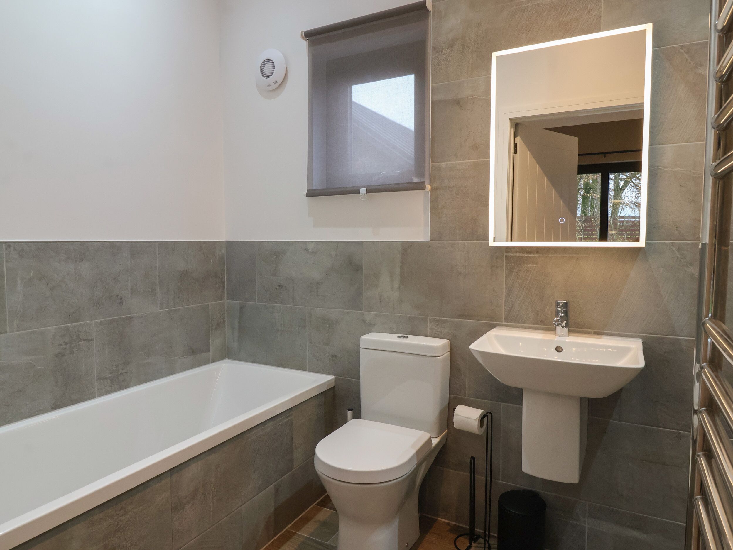 A modern bathroom with a bathtub, toilet, and sink.