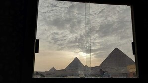 Vista de las pirámides a través de una ventana con un marco oscuro y sencillo.