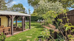 A covered patio with a pool, a lawn, and various plants. - 4 bedroom accommodation in Lymington (Lymington)