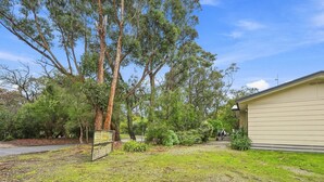 A residential property with a house, a fenced yard, and surrounding trees. - Kyeema Inverloch, Wifi and Pet friendly outside only (Inverloch)
