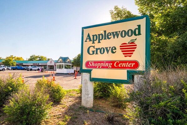 A sign for Applewood Grove Shopping Center with a strawberry symbol.