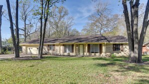A two-story house with a front porch, surrounded by trees. - Beaumont Rental Home ~ 2 Mi to Gulf Terrace Park! (Beaumont)