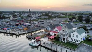 Une propriété située au bord de l’eau, dotée d’un quai, d’une grande maison avec un toit rouge et d’un parking.