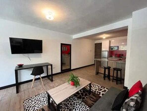 Cozy living space with a flat-screen TV, dining area, and kitchenette.