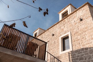 A stone building with a balcony and a window. - Villa Imagination with Pool (Gornji Humac)
