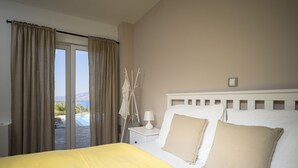 A bedroom with a bed, a nightstand, a lamp, and a view of a pool and mountains. - Villa Pharia with Pool V (Stari Grad)