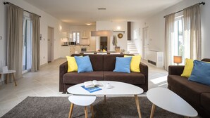 A modern living room with a brown sofa, two white coffee tables, and a rug. - Villa Pharia with Pool VIII (Stari Grad)