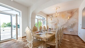 A dining area with a large table set for six, surrounded by ornate chairs. - Villa Piano with Pool (Matulji)