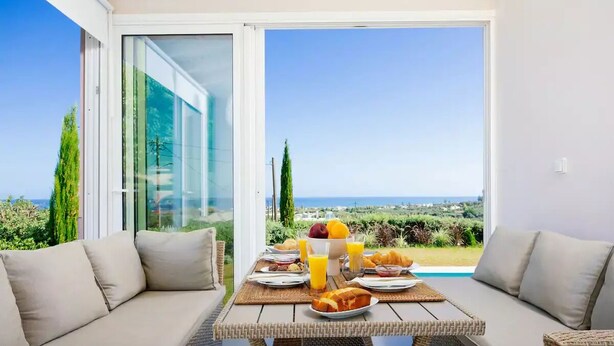 Un balcón con una mesa dispuesta para el desayuno, con vistas a un paisaje pintoresco.