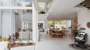 A modern, open-plan living space with a dining area, kitchen, and a view of the outdoors.