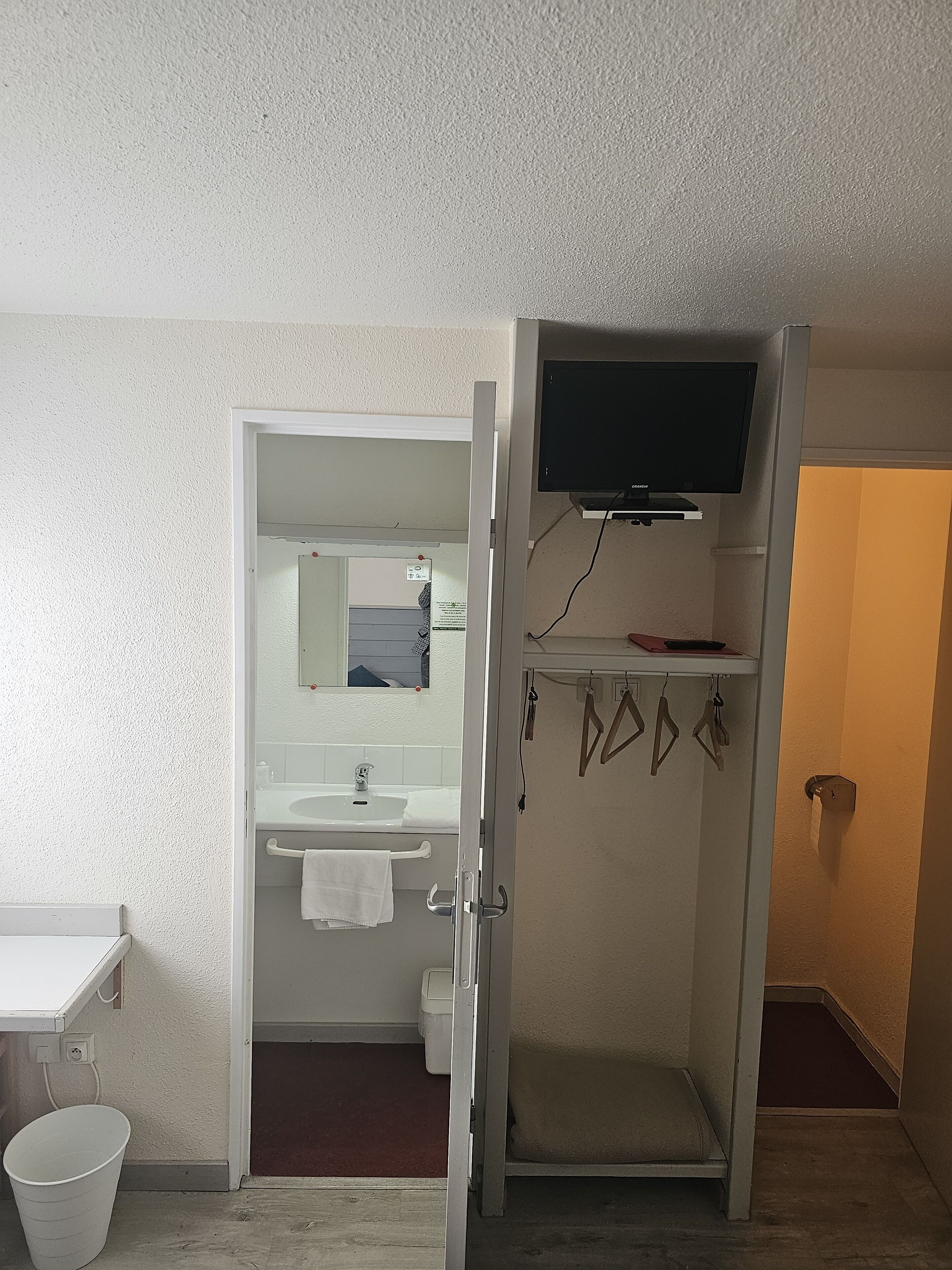 Une salle de bain équipée d’un lavabo, d’un miroir et d’un porte-serviettes.