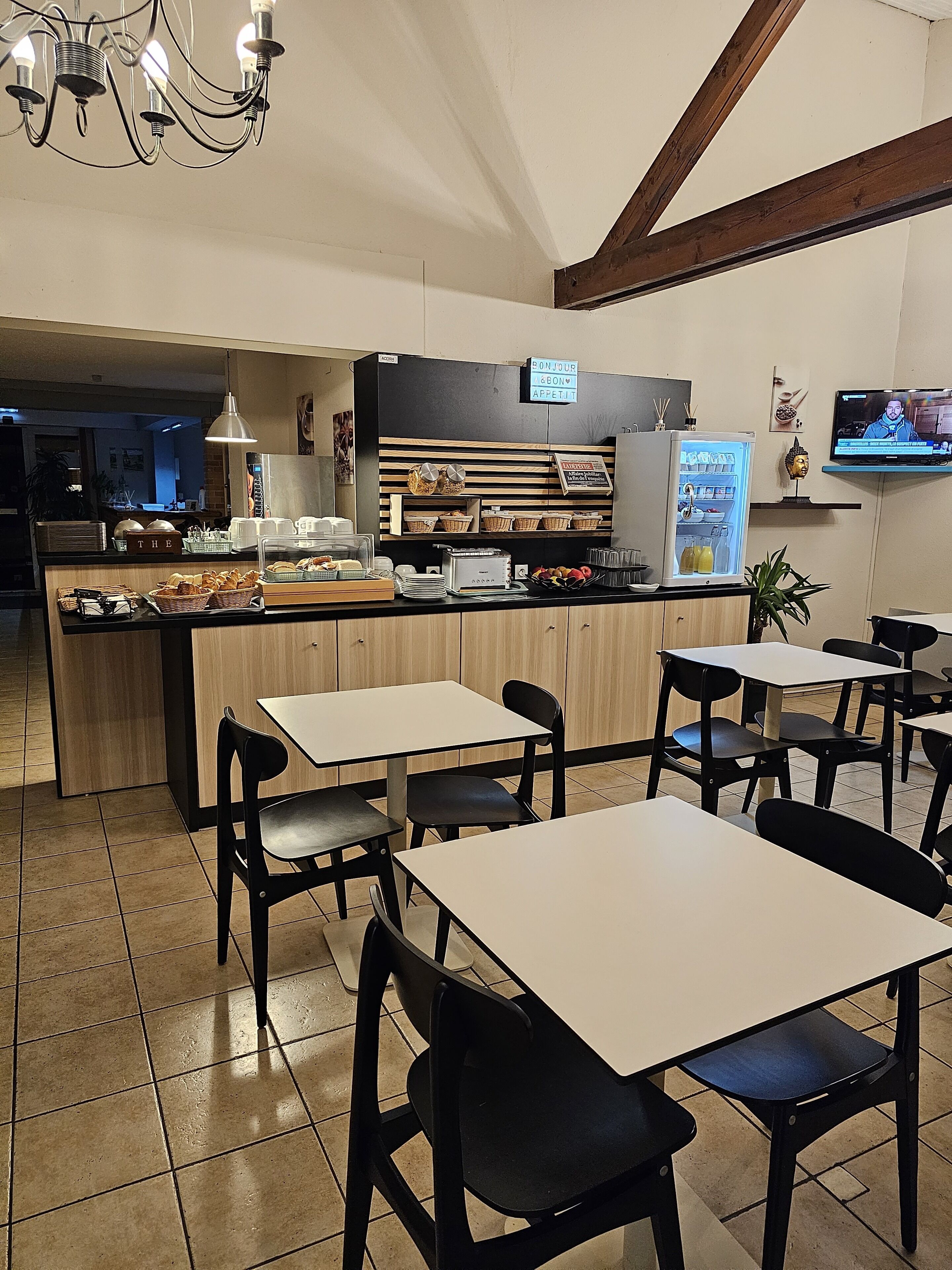 A restaurant with a central counter, tables, and chairs.