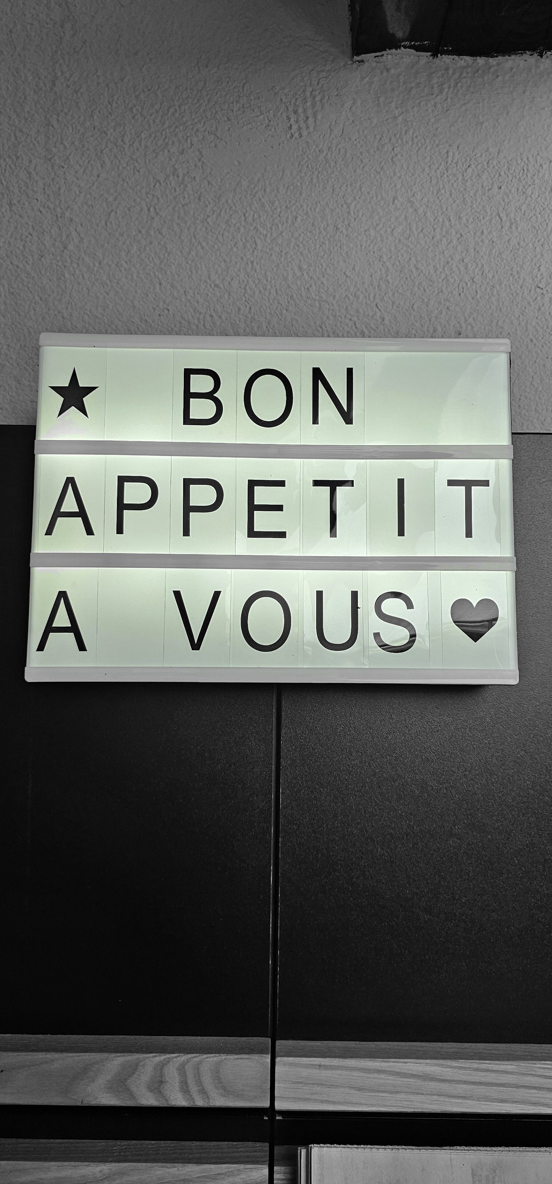 A light-up sign with the message "BON APPETIT A VOUS" and decorative symbols.