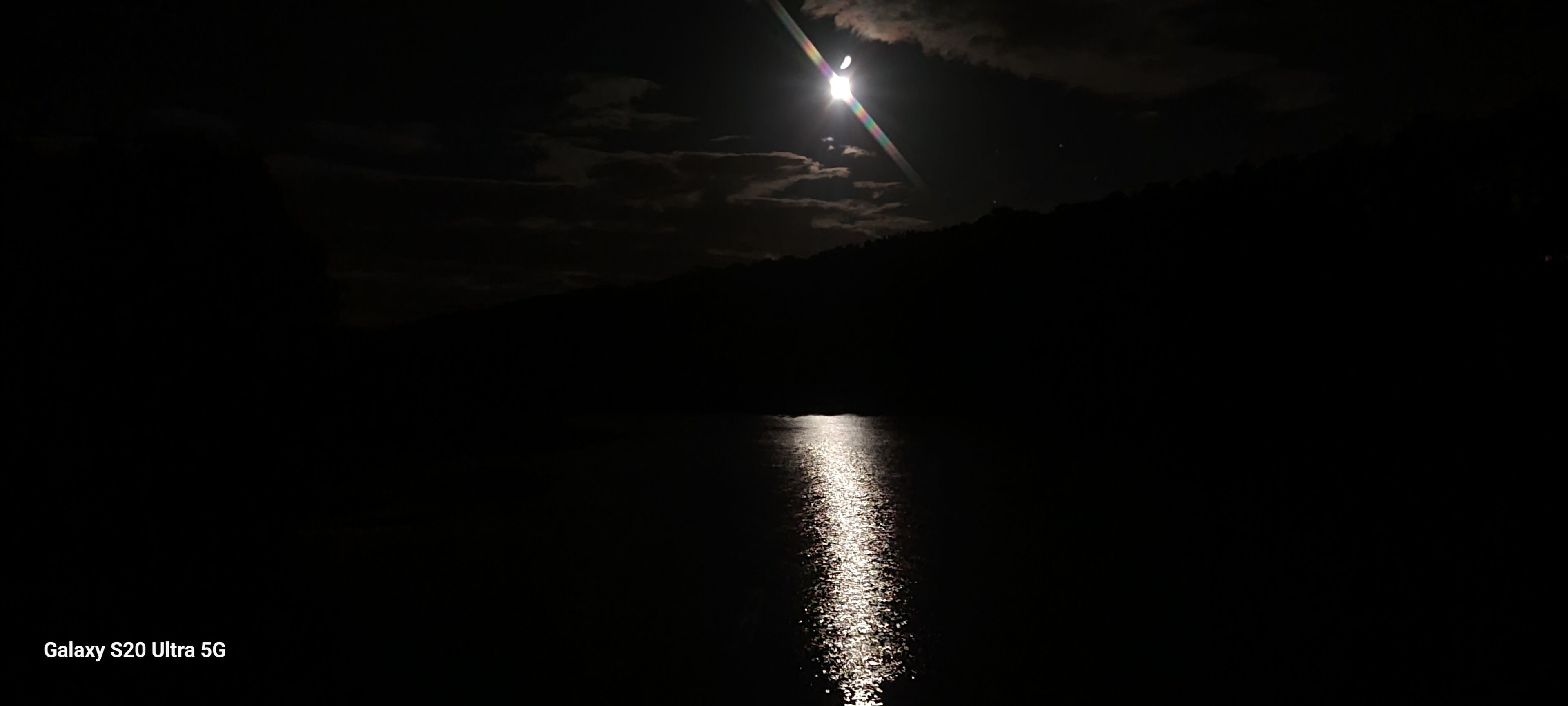 Una escena nocturna con la luna reflejada en el agua.