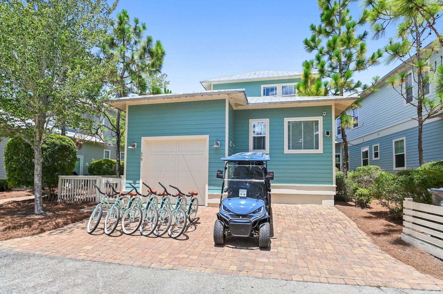 Un edificio residencial con garaje, un aparcamiento para bicicletas y un carrito de golf.