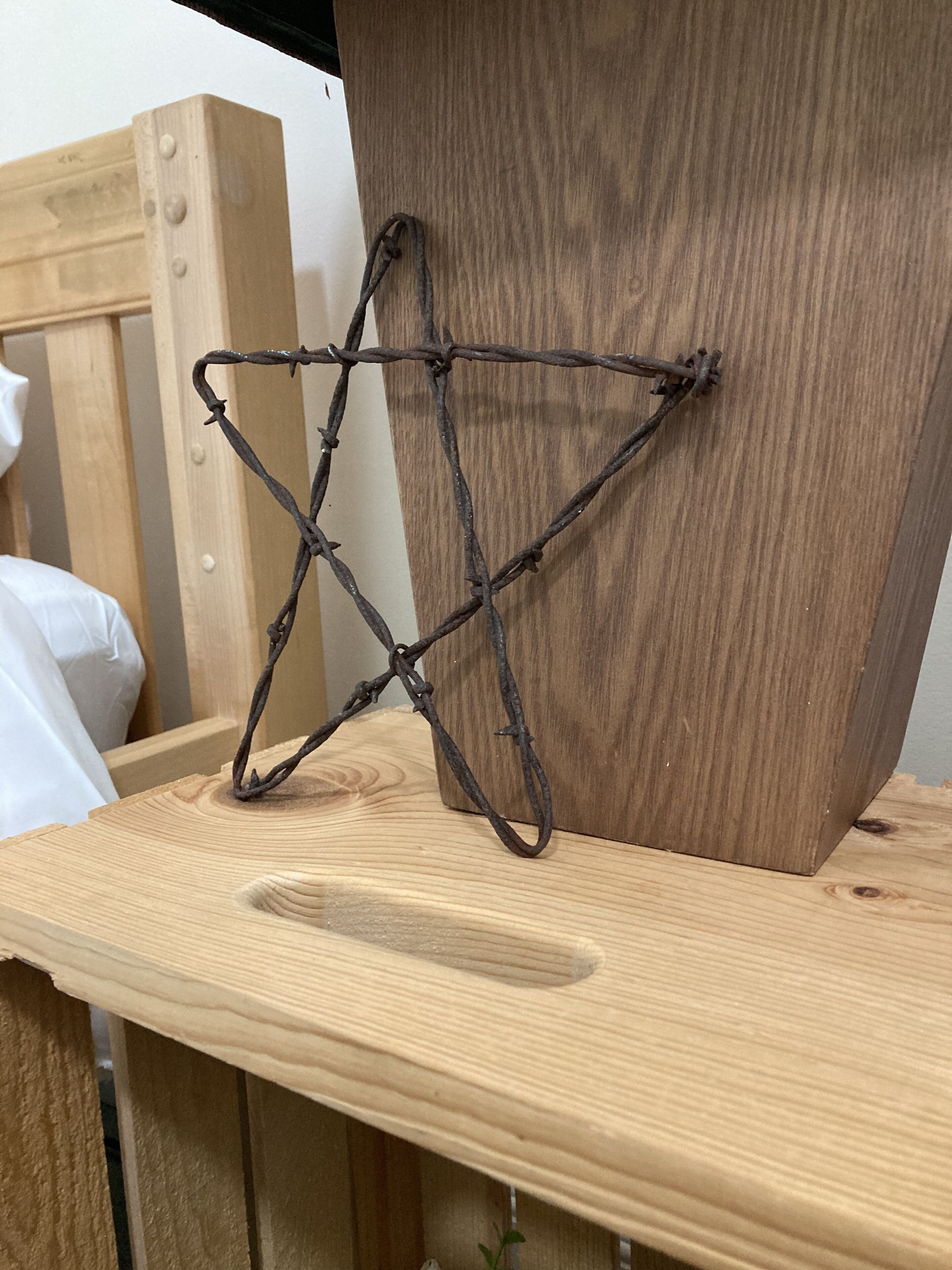 A wooden bedside table with a metal bar structure attached to it.