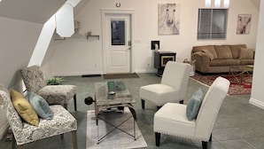 A living room with a loft-style ceiling, a fireplace, and a brown sofa. - Relaxing Country Retreat close to all amenities. Great for the whole family! (North Saanich)