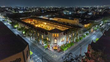 A historic building with a central courtyard, surrounded by trees and a street.