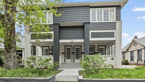 A two-story house with a front porch, a garage, and a number "1728" on the front. - Pink on Delaware, Spacious 2BR Downtown Indy (Indianapolis)