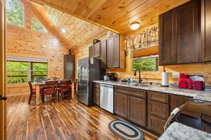 A wooden cabin interior with a kitchen, dining area, and a view of the outdoors. - Cliffview Resort Lakefront 4BR, 3BTH- No Smoking/Pets. Fishing Dock, Game Rm. (Campton)