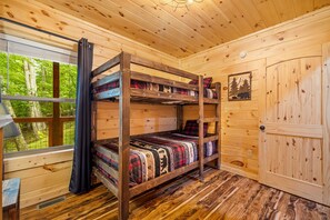 A bunk bed with multiple bedding patterns, a window with curtains, and a door with a wooden panel. - Cliffview Resort Lakefront  4BR, 3BTH- No Smoking/Pets. Fishing Dock, Game Rm. (Campton)
