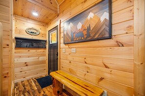 Un interior de madera con un banco, una puerta y un letrero de bienvenida.