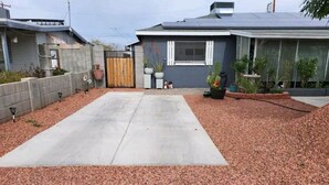 Ein Auffahrt mit einem Betonweg, der zu einem Haus führt.