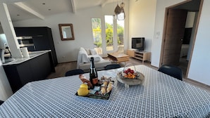 Ein modernes Wohnzimmer mit Essbereich, Küche und Fernseher.