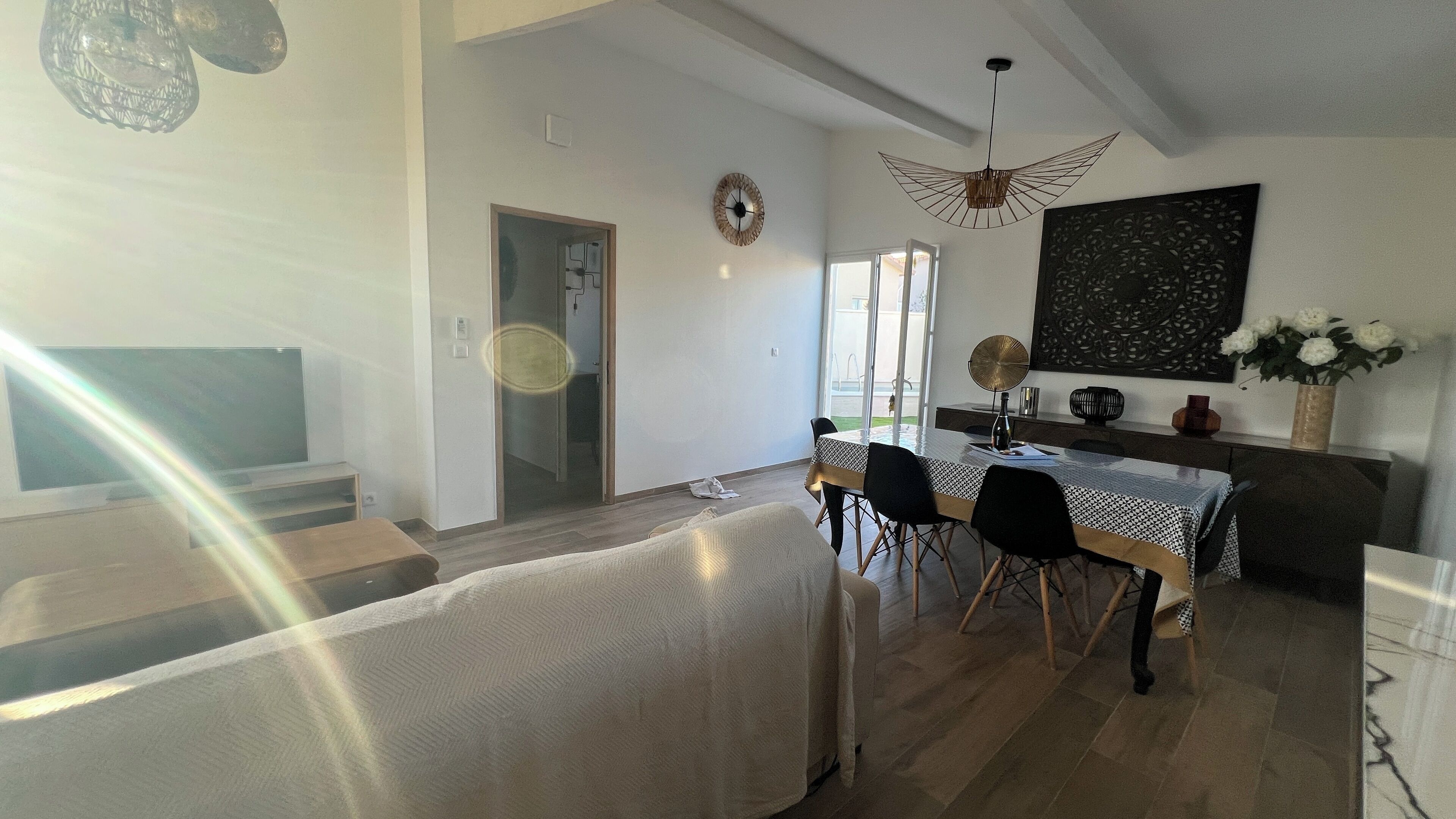 Un grand espace de vie comprenant une table à manger, des chaises, un canapé et un téléviseur.