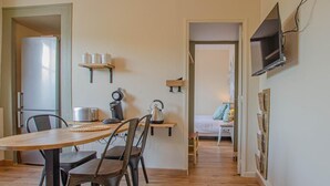 A compact living space with a dining area, kitchenette, and a bedroom. - L'Idéal - SAINTE SAVINE (SAINTE SAVINE)