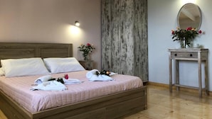 Ein Schlafzimmer mit einem hölzernen Bett, weißen Kissen, einem Nachttisch mit Blumen und einer Wand-Klimaanlage.
