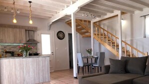 Ein moderner Wohnraum mit Küche, Essbereich und Treppe.