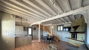 A spacious living area with a kitchen, dining area, and a staircase leading to an upper level. - Eris Villa - Amazing View In Lefkada (Lefkada)