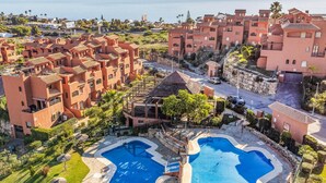 Een resort met meerdere gebouwen, een zwembad en uitzicht op zee.